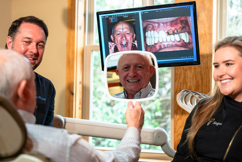 patient smiling brightly with doctor and staff member after their dental procedure